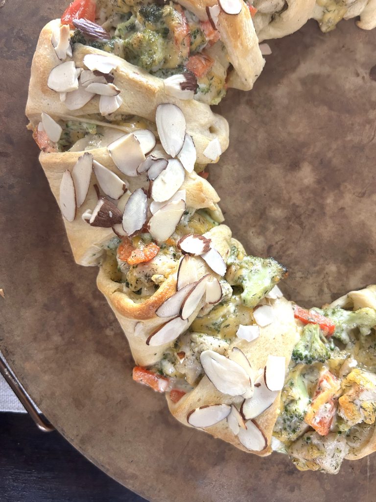 A close up of baked chicken broccoli braid on a baking stone