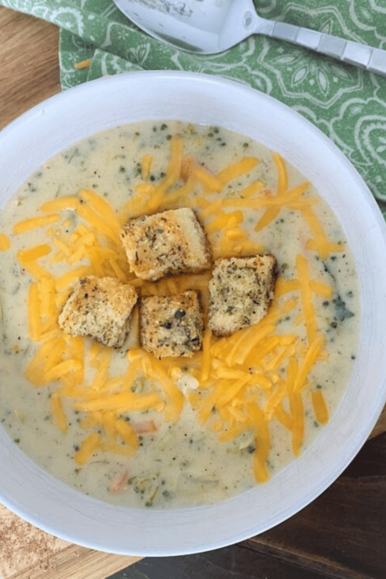 Homemade broccoli soup in a white bowl on a green paisley napkin