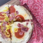 A personal pan homemade pizza cut in 4 on a wooden cutting board