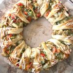 A fullly assembled and baked chicken broccoli braid on a round baking stone